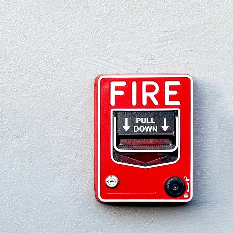 Red fire alarm pull station mounted on a wall